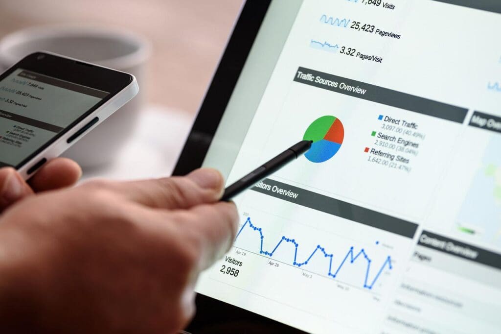 man pointing a pen to a laptop screen on website analysis page