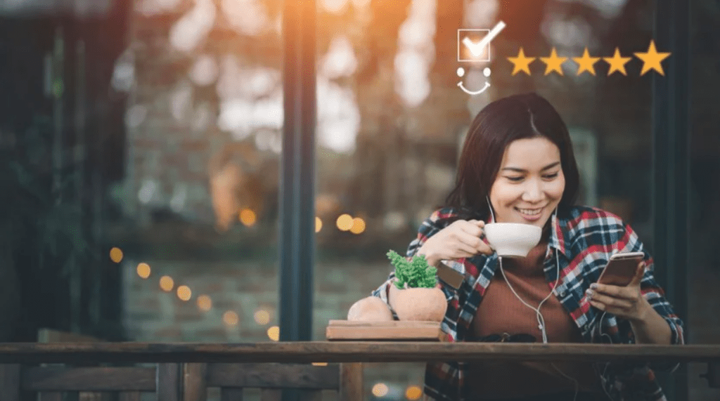 Customer leaving a 5 star review on her phone, a result of customer retention strategies